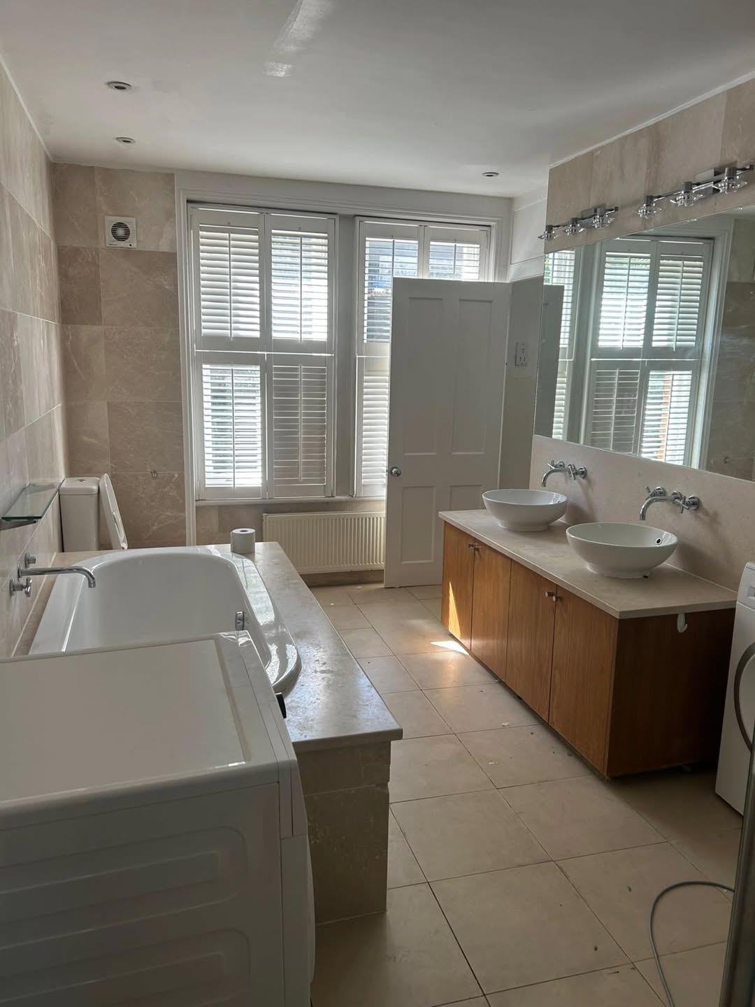 Refurbished bathroom with double basins and shutters