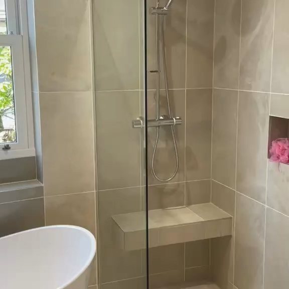 Tiled shower enclosure with glass screen