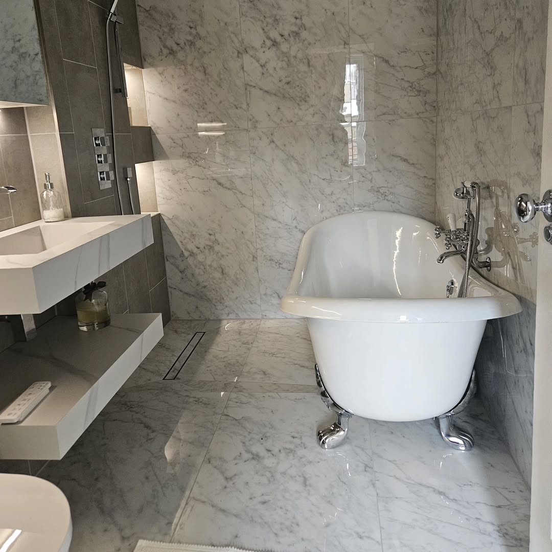 Freestanding bath in a marble-tiled bathroom